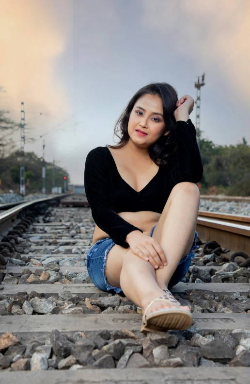 a woman sitting on the rail road tracks