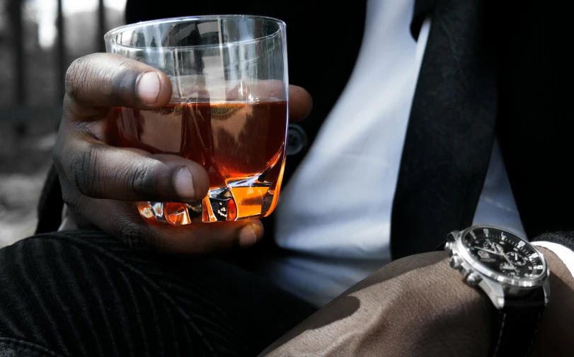 man holding a glass filled with soing and showing it's empty