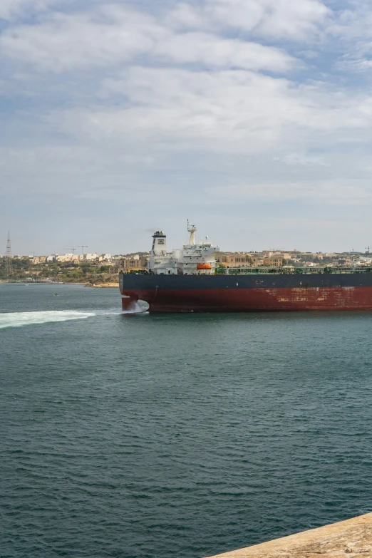 a large cargo ship passing by another boat in the water
