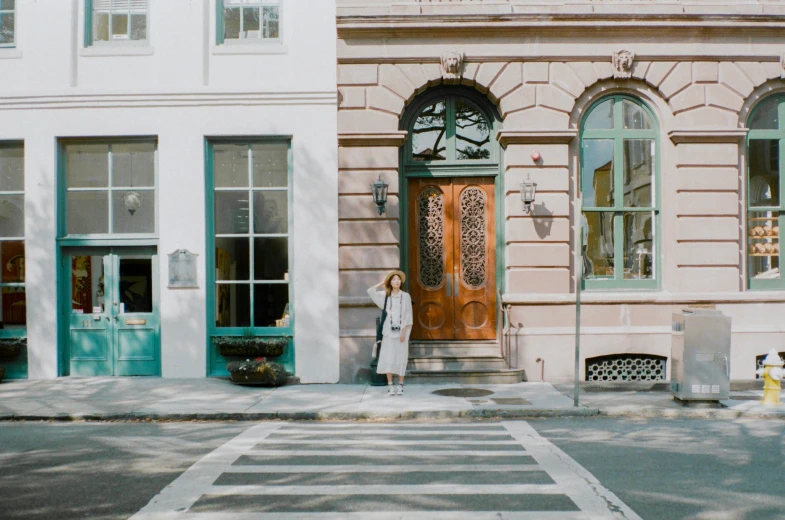 a woman is standing at the entrance of a building with a clock on the door