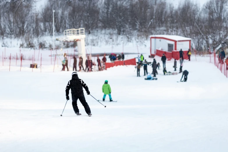 a snow skier on snowy slope near a group of people