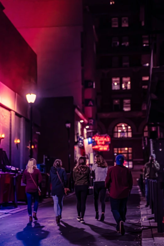 people are walking down the street at night