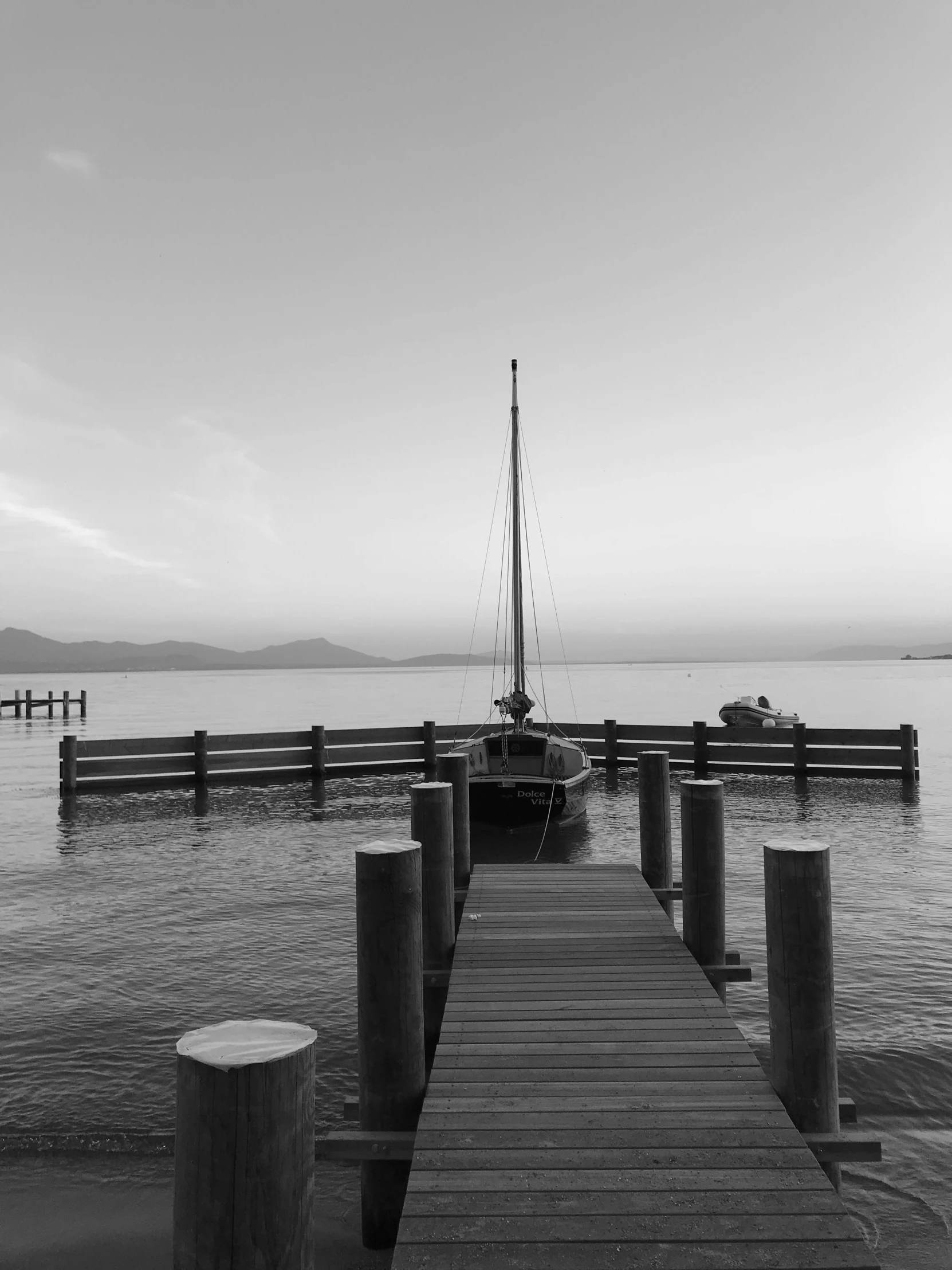 the dock is surrounded by a few poles and two boats