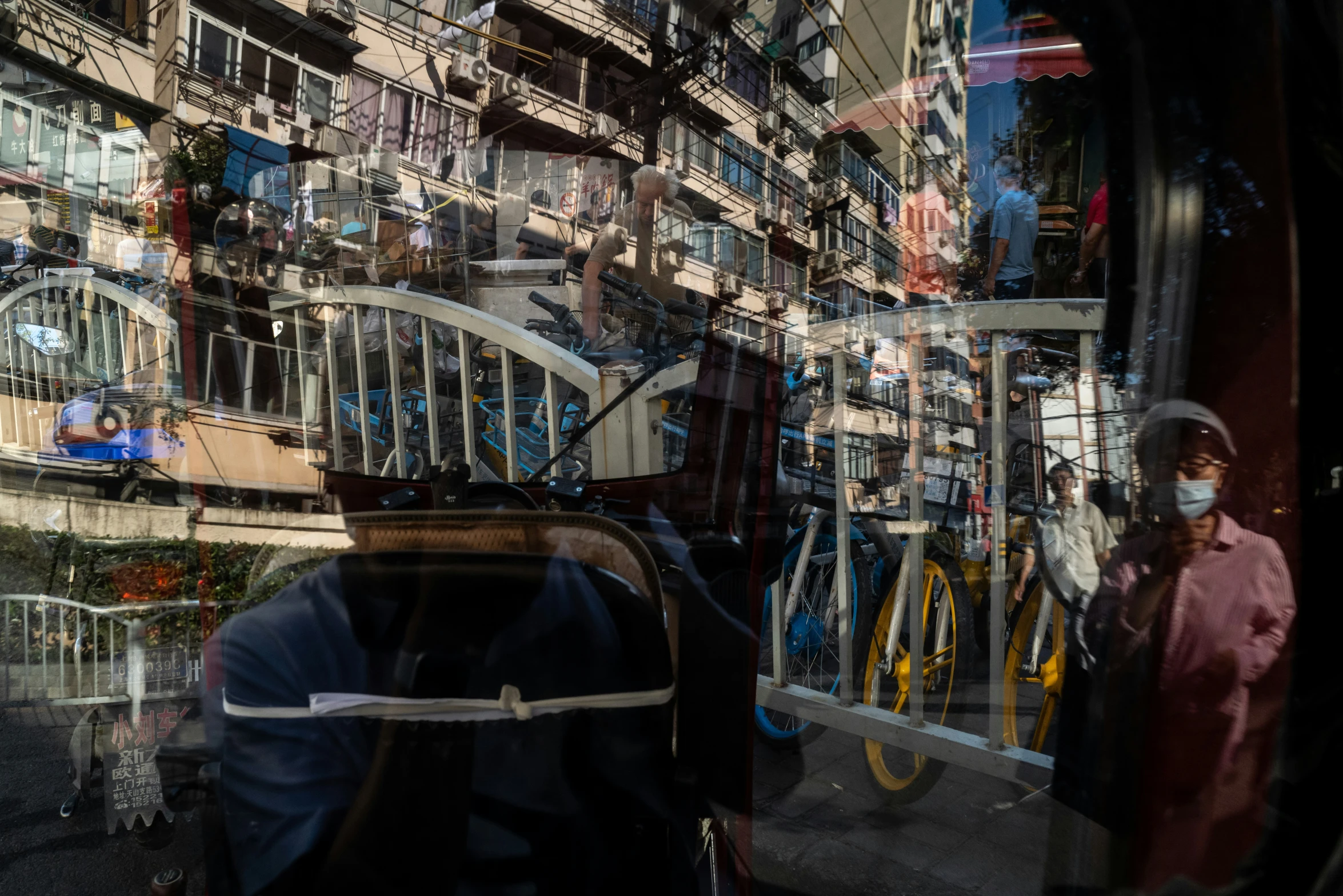 the storefront of a bicycle shop is reflected in a glass