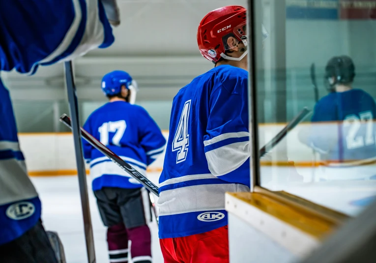 two hockey players are standing next to an ice rink