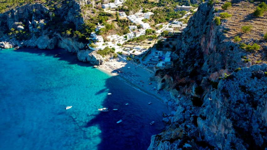 an aerial view of a beach that has several boats