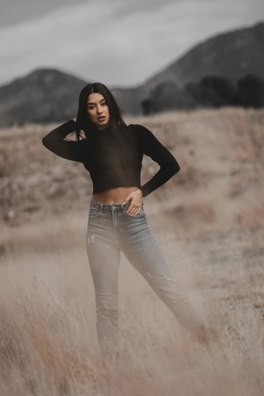 a woman standing in a field with a black shirt