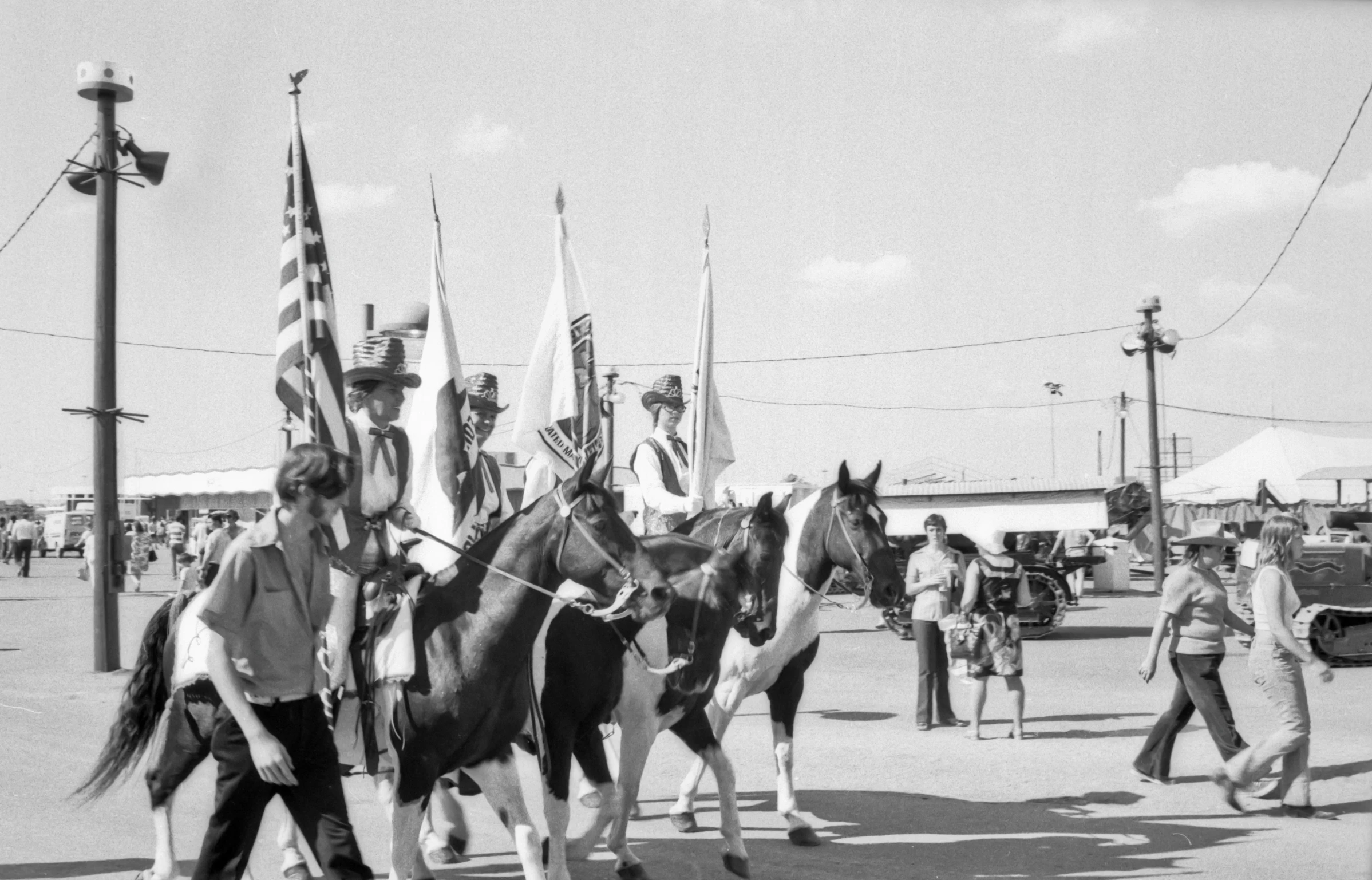 some people are riding on horses that have flags