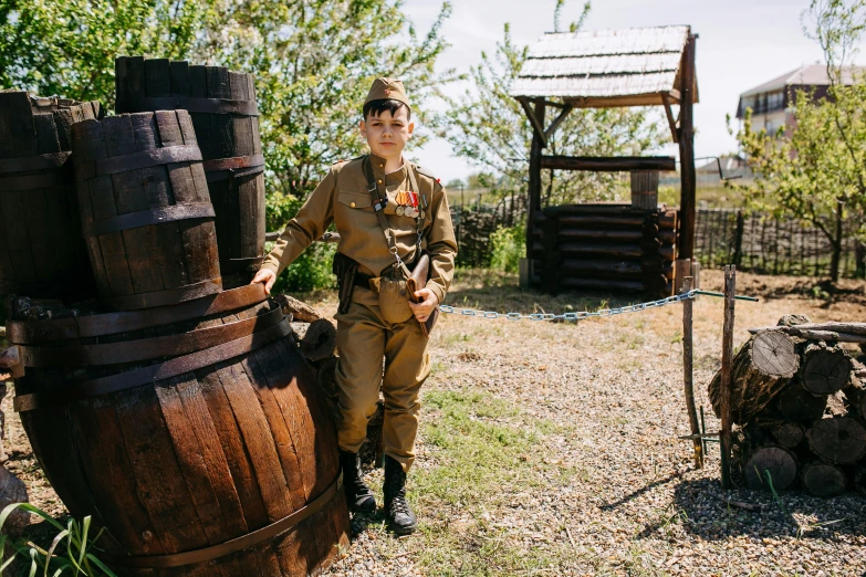 a man in a military uniform standing next to a stack of barrels