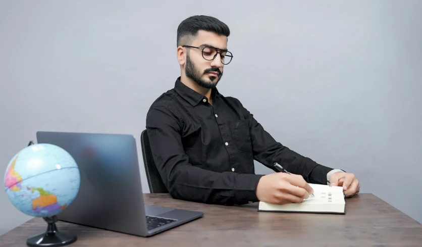 the man is typing on his laptop computer