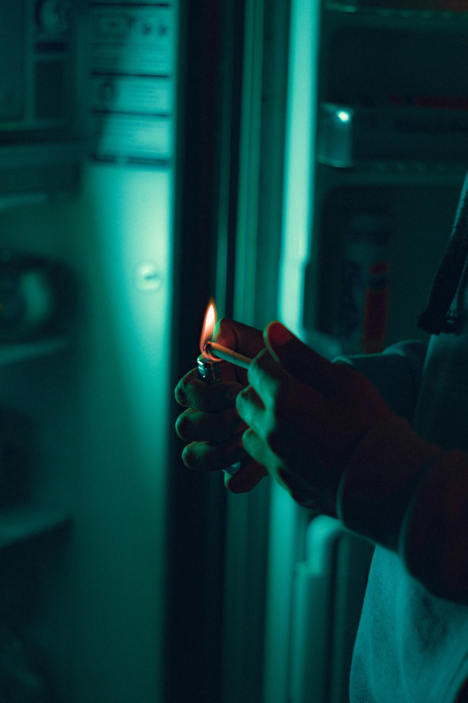 a woman holding a lit up cigarette in a dark room