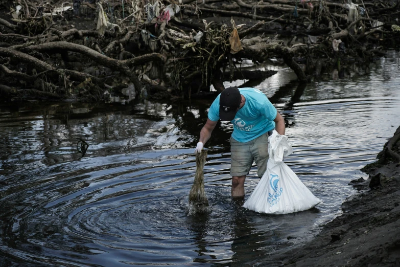 a man in the water collecting soing off of the shore