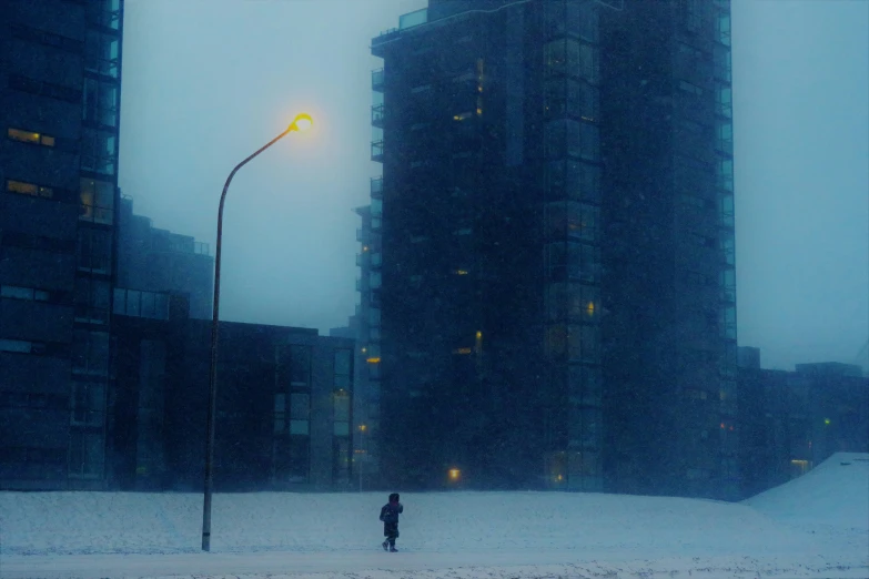 a city street is covered in snow with a person walking across the street