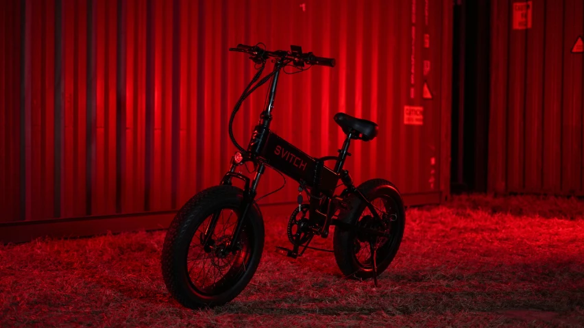 a bike is lit up next to a building