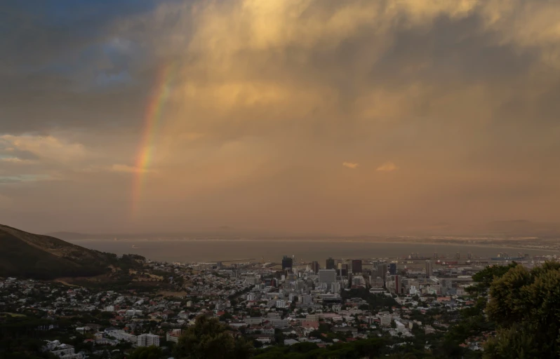 rainbow above the city and its surrounding trees