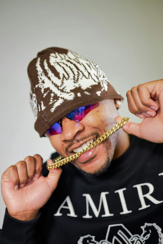 a man wearing a hat is posing with chains on his ear