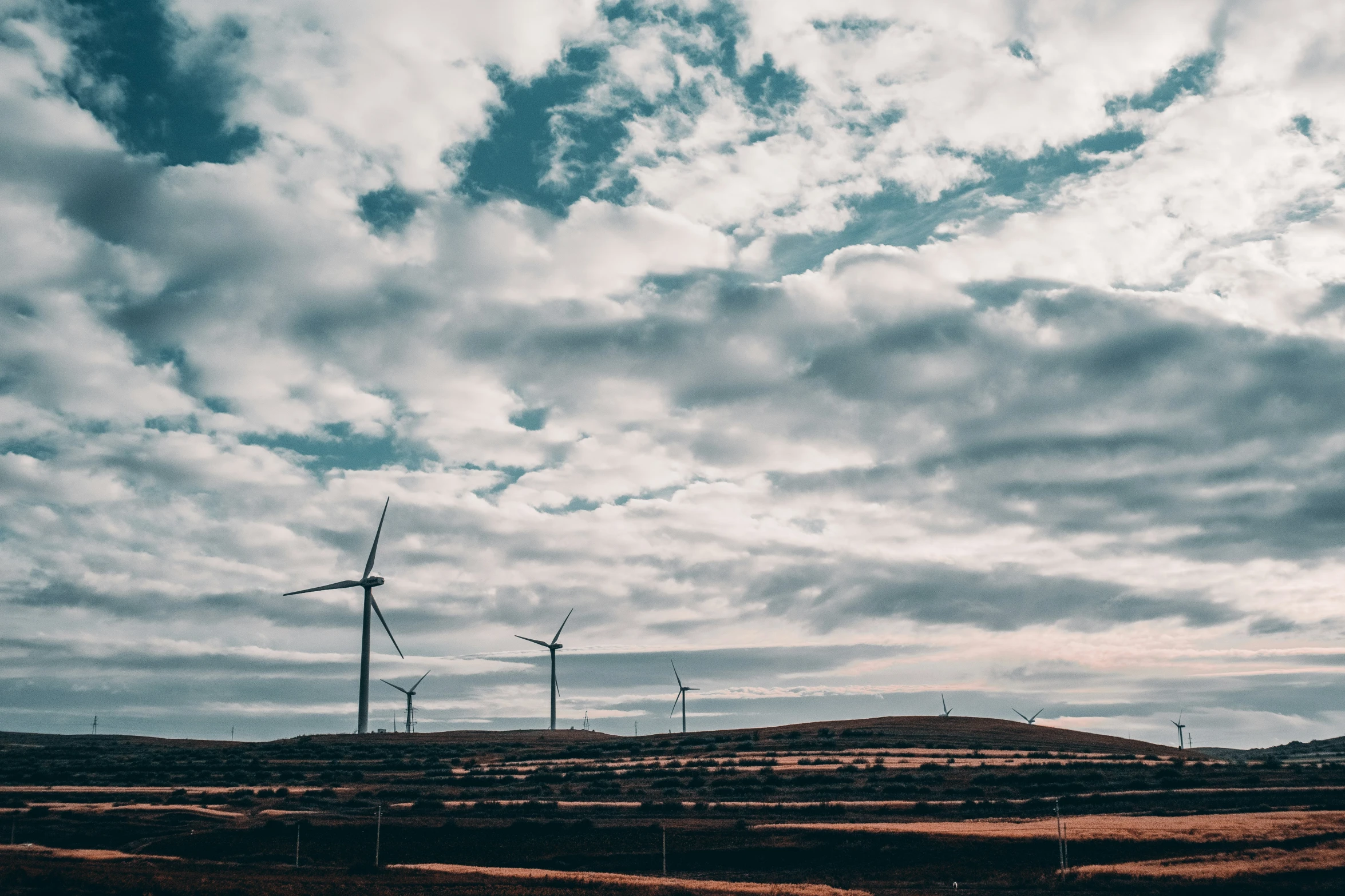 a field that has several wind mills in the middle of it