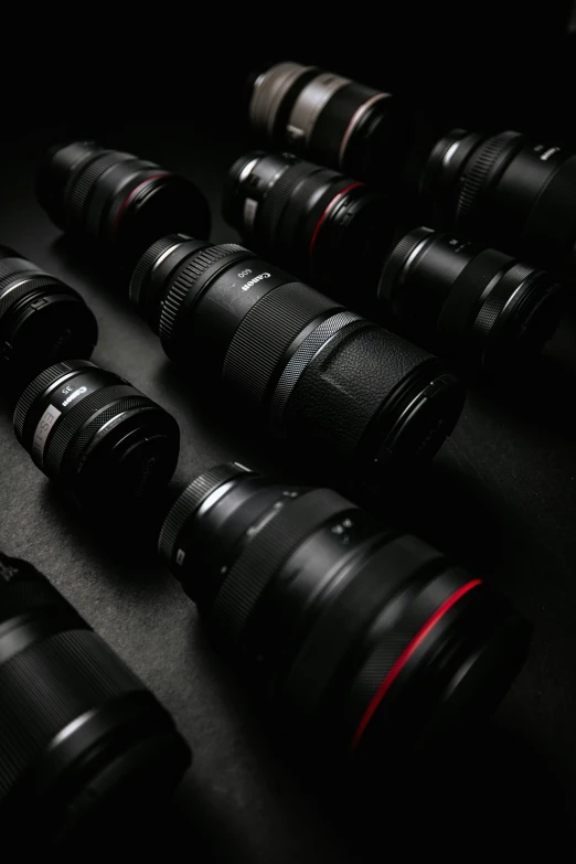 a couple of black camera lens's sitting on a black surface