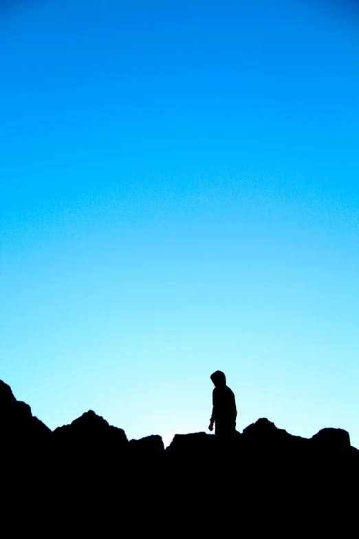 the person is standing next to the mountains alone