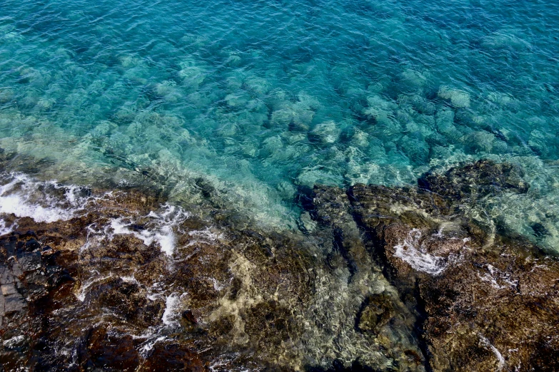 some blue and green water and rocks in the ocean