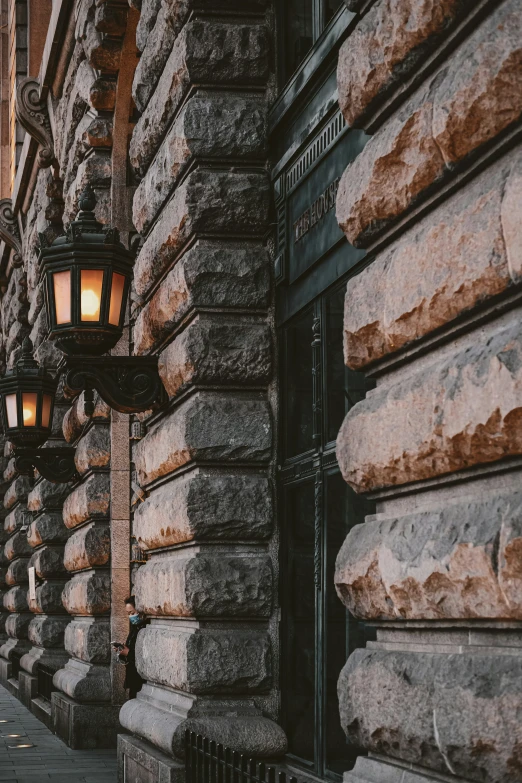 a light on a brick building next to a road