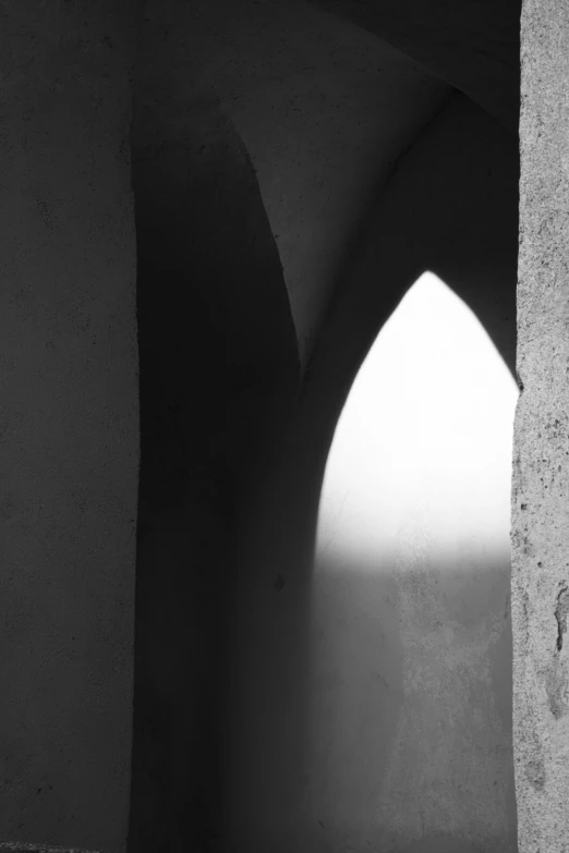 a light shines through the top part of an arch