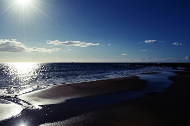 a blue sky on a sunny day with the sun reflecting off the ocean