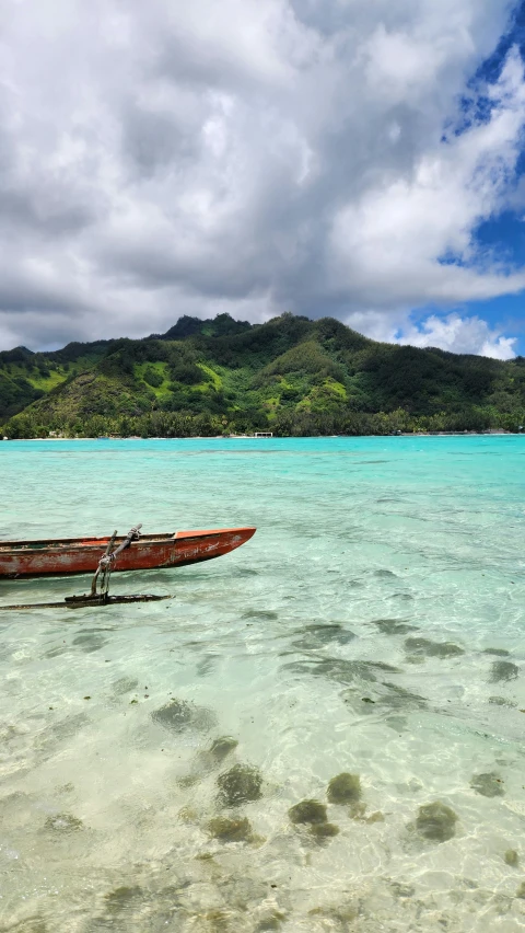 a canoe sits on the edge of clear water