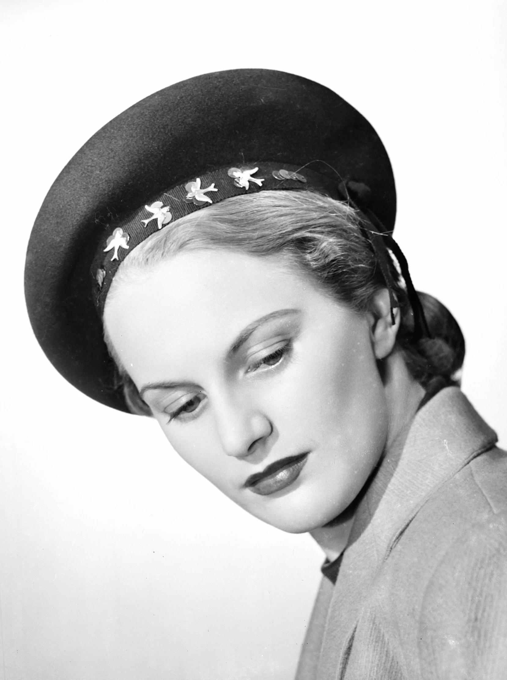 a woman wearing a big hat with flowers on it