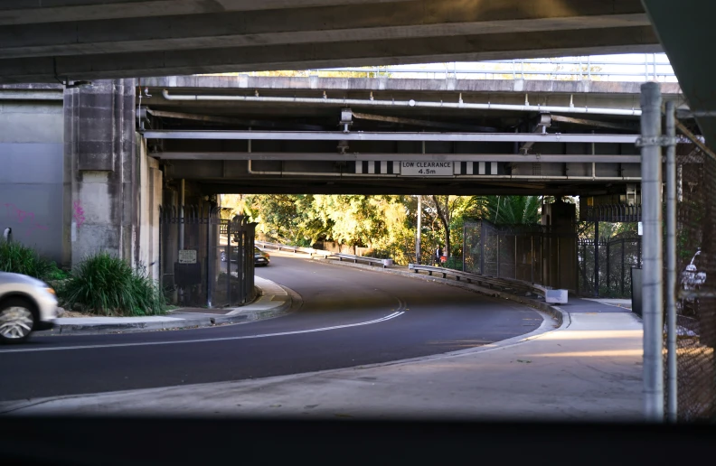 a white car parked on the side of a road under a bridge