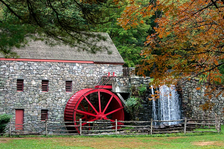 the water mill is in front of the fall tree
