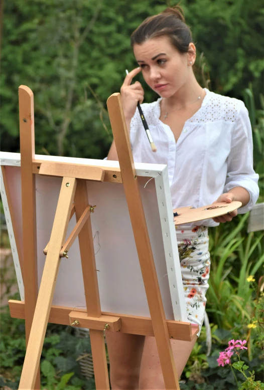 a woman with an easel in her hand painting