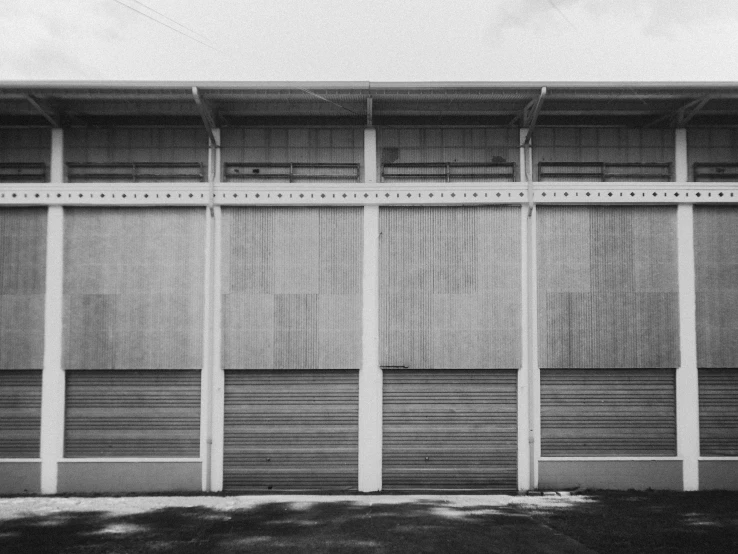 an empty bench against a building made of columns