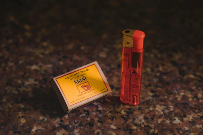 a yellow box on a marble surface next to a lighter