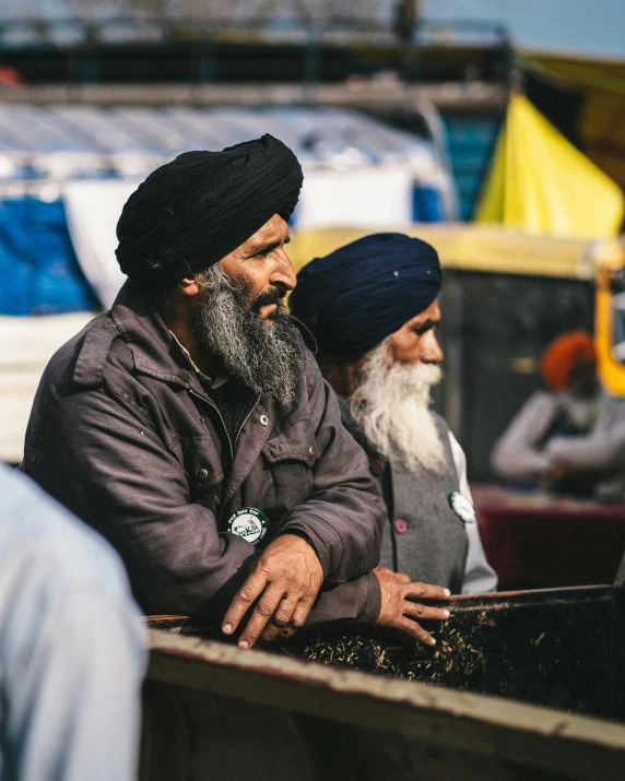 two men sitting side by side on the ground