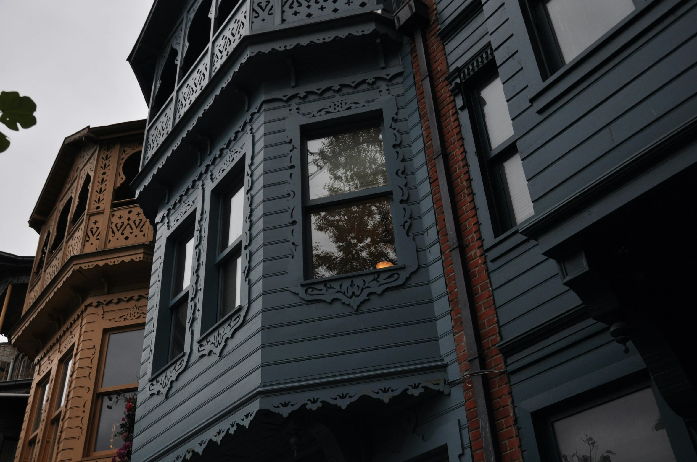 an old victorian style building is painted blue with decorative trim