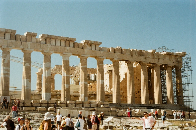 a group of people standing around and walking outside of a stone building