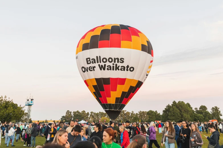 a balloon with the words balloons over waitao on it being held by many people