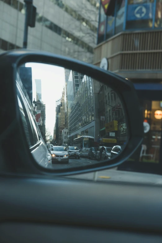 the side view mirror of the car shows many traffic