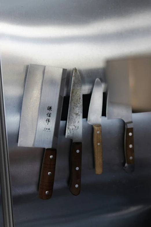 a close up of four knives in a metal holder