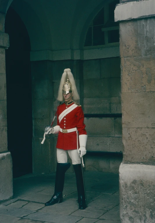 a guard dressed in a red uniform holding his rifle