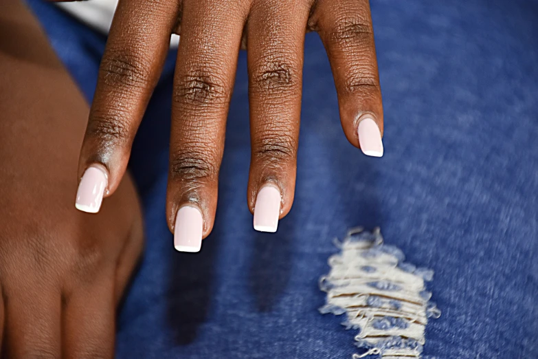 a woman wearing white and blue is holding her hand up in front of her