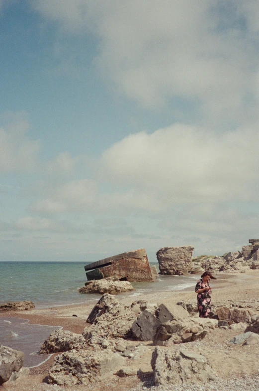 a person standing on a beach with an umbrella