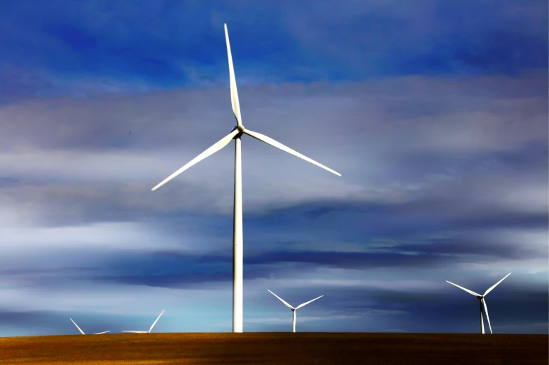 a row of wind turbines towering into the blue sky