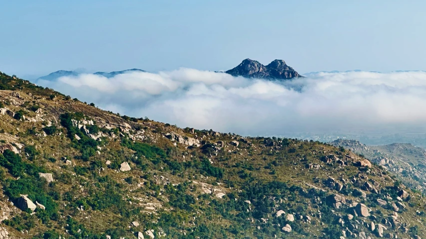 a mountain with some cloud in it with mountains below