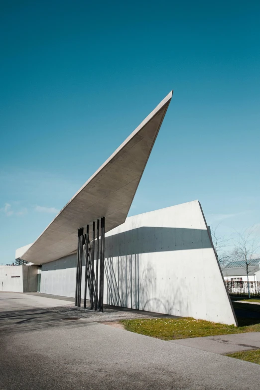 a white building with a triangular roof and metal poles
