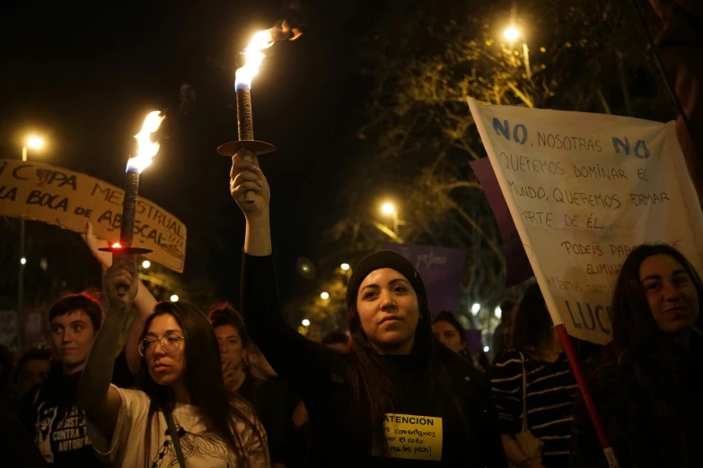 people stand in front of the camera, holding up placards