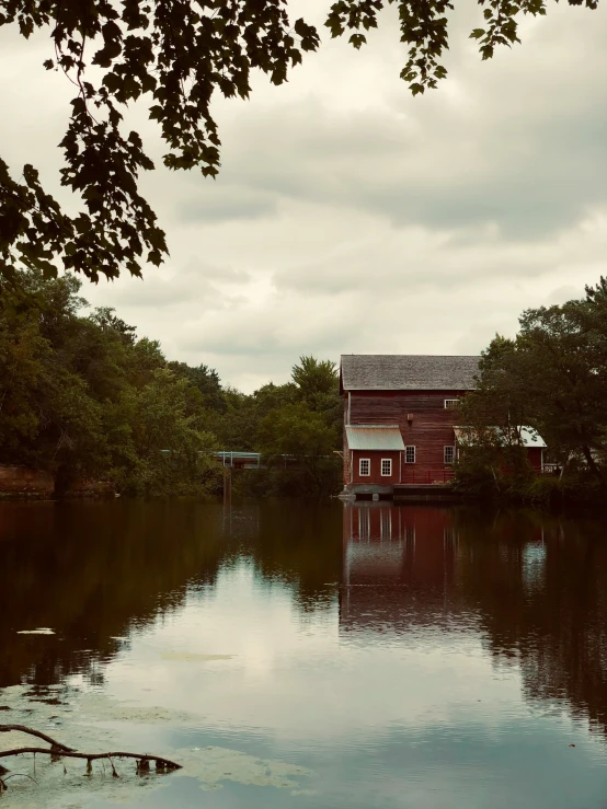 a cabin sits by the water on a cloudy day