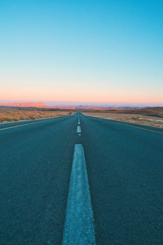 the empty road that has two lanes goes up in the sky