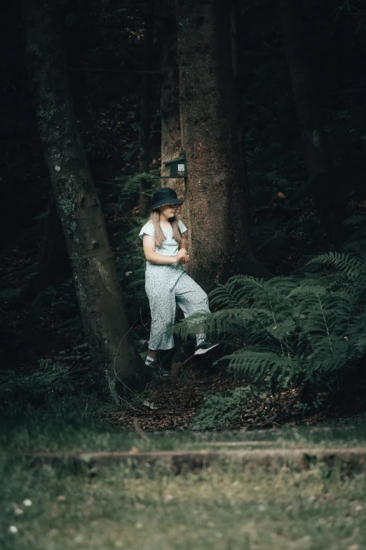 a man standing in the woods holding a wooden stick